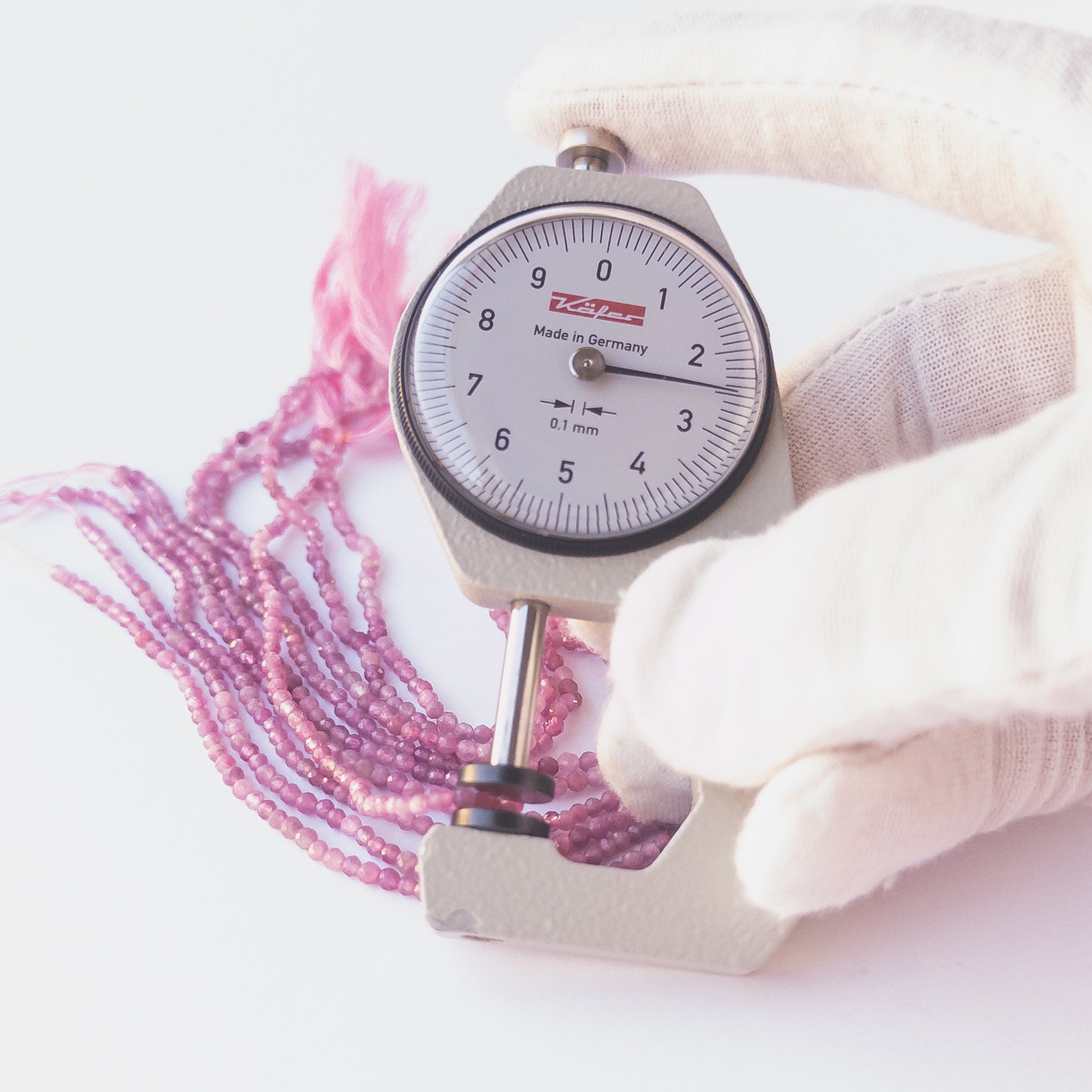 A dial gauge measures the Pink Tourmaline faceted rondelle 2.4–2.5mm gemstone.