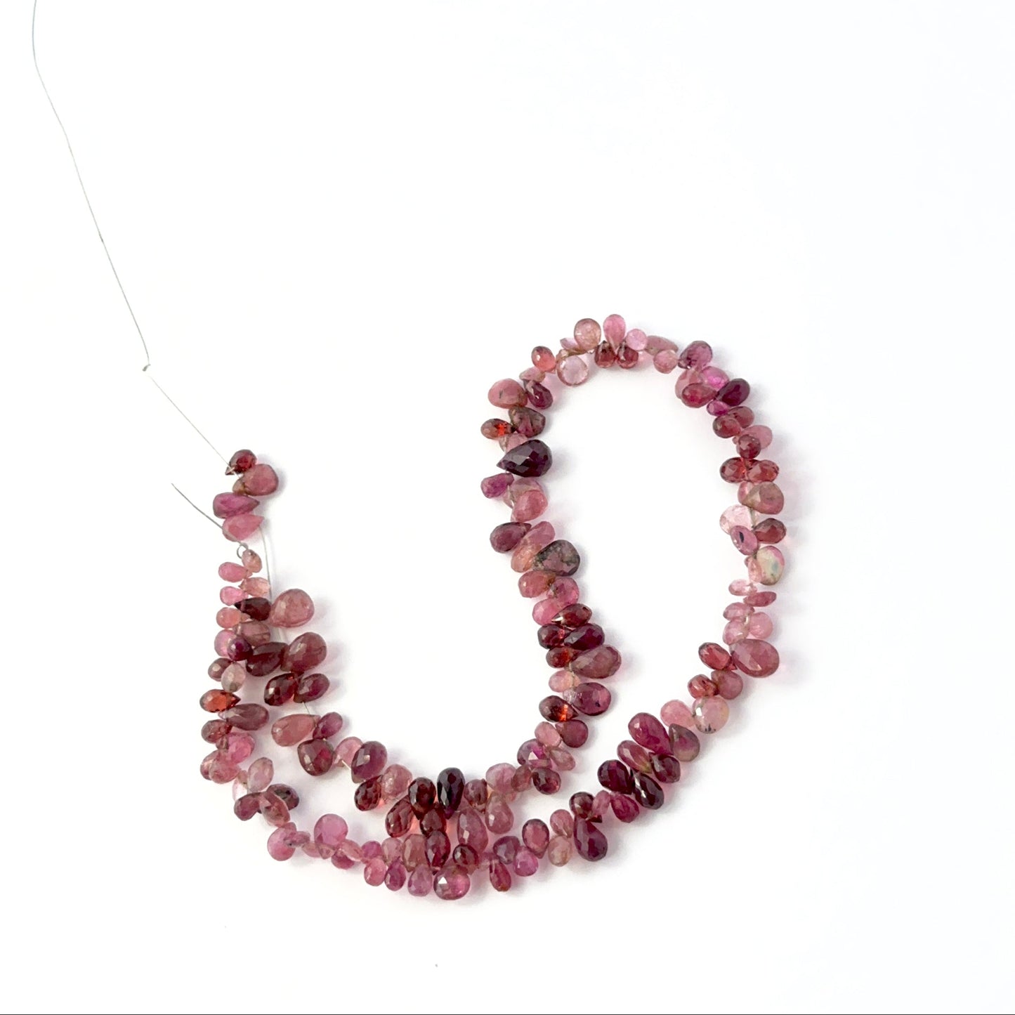 Pink tourmaline faceted teardrop briolettes with bright sparkle, arranged on a 30cm strand for handmade jewellery components.