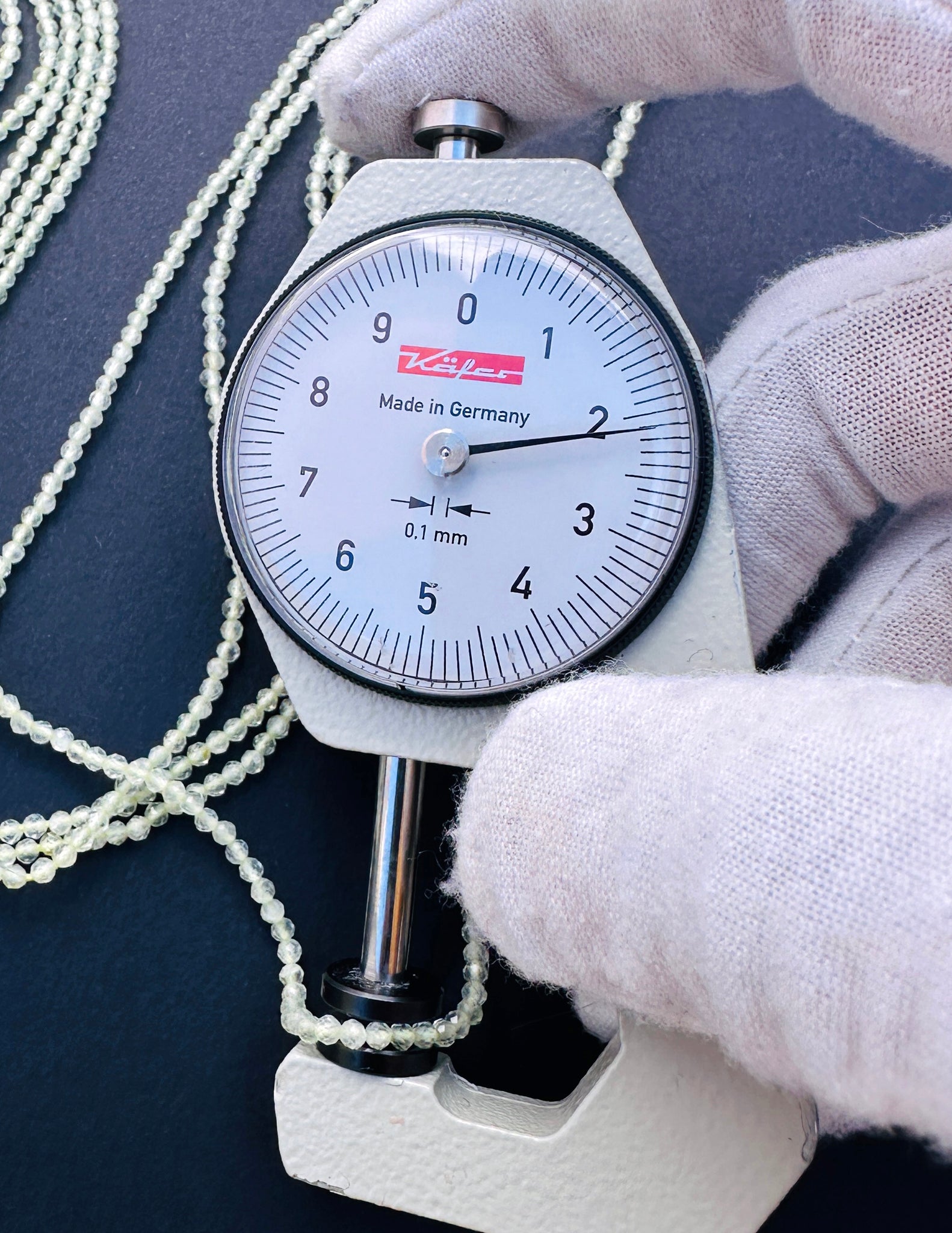A dial gauge measure Prehnite faceted rondelle beads.