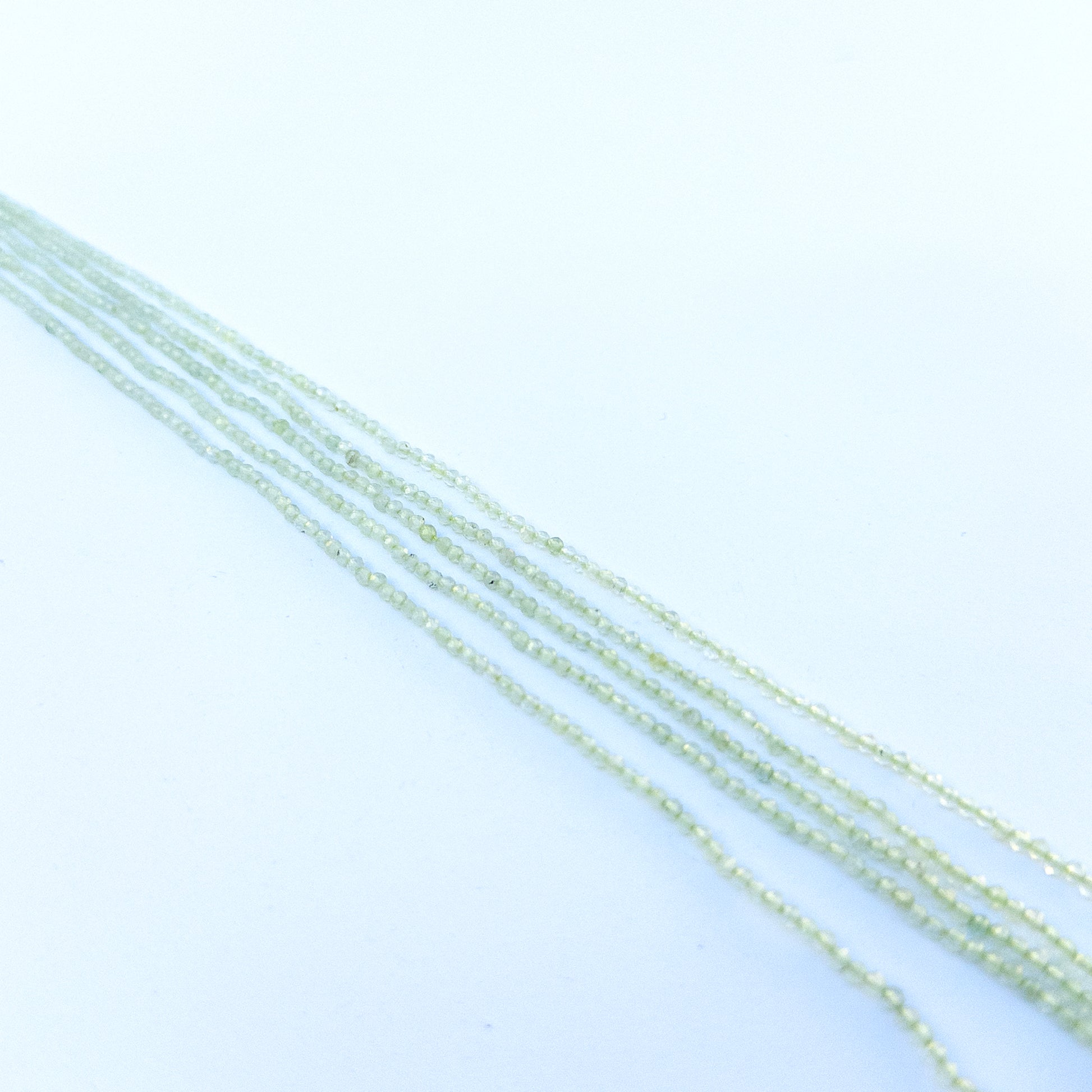 Detailed view of 2.2mm prehnite rondelles with crisp faceting and smooth polish for handmade jewellery components.