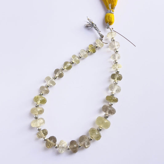 Close-up of natural gemstone beads showing the faceted rondelle cut and translucent green glow.