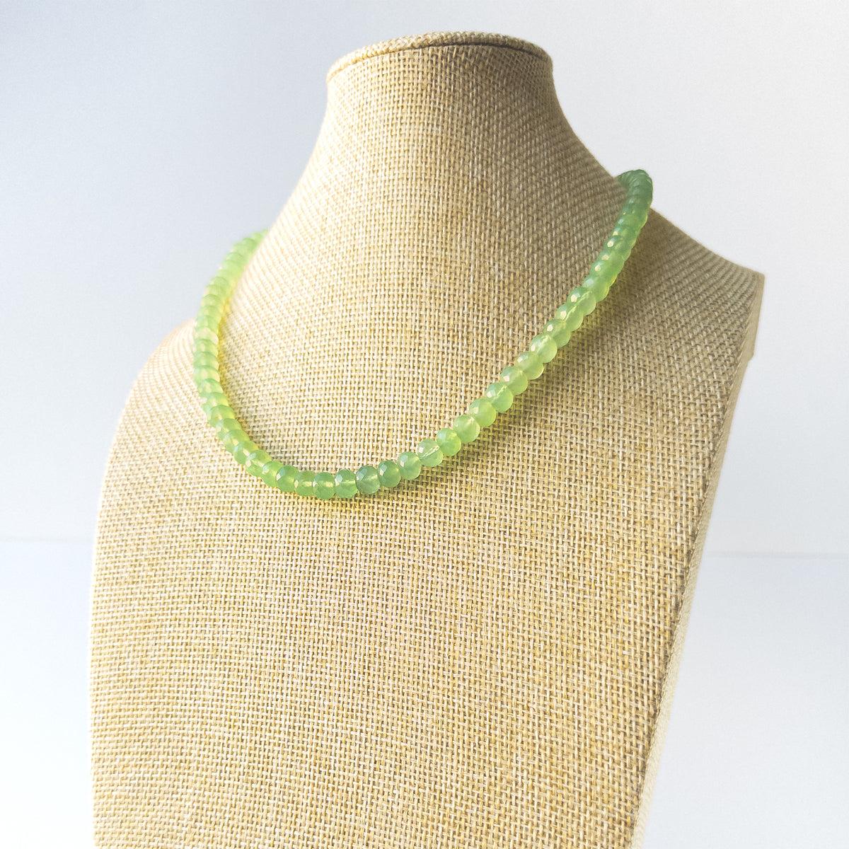 Genuine Prehnite stone beads with crisp faceted rondelle shaping arranged in an elegant necklace.