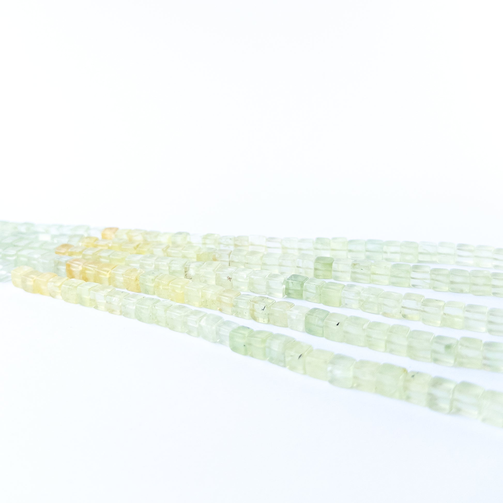 Authentic Prehnite gemstone beads showcasing calming green colour and smooth cube shaping for jewellery designers.