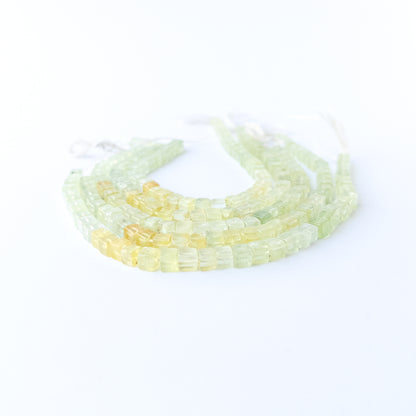 Prehnite smooth cube gemstone beads in soft green tones arranged on a 20cm strand for handmade jewellery components.