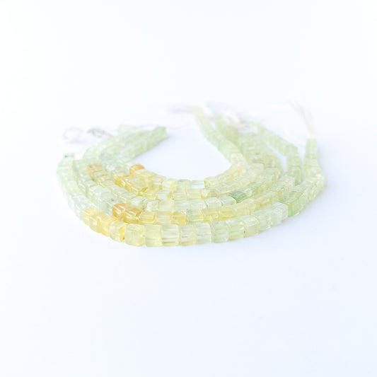 Prehnite smooth cube gemstone beads in soft green tones arranged on a 20cm strand for handmade jewellery components.