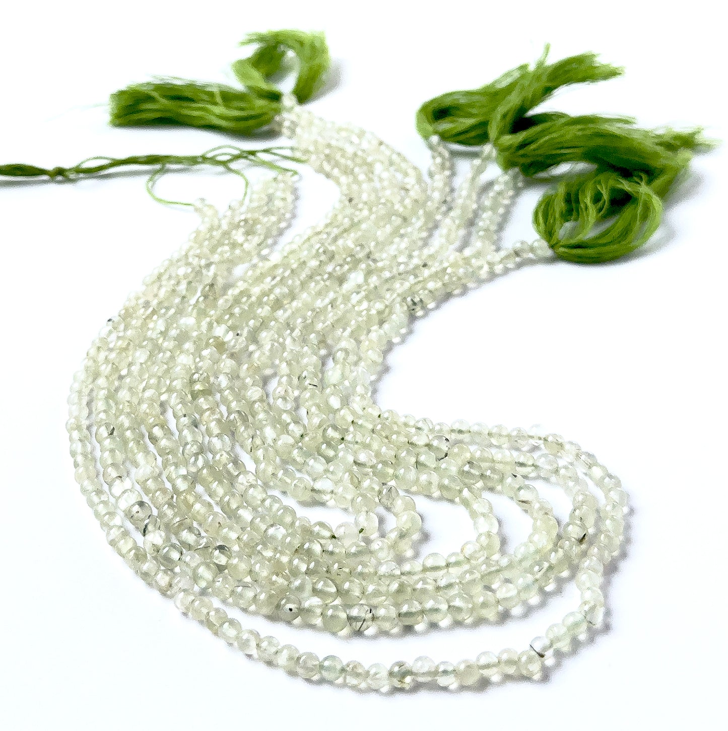 Prehnite round beads featuring smooth surfaces, subtle internal cloudiness, and consistent 4–4.3mm sizing.