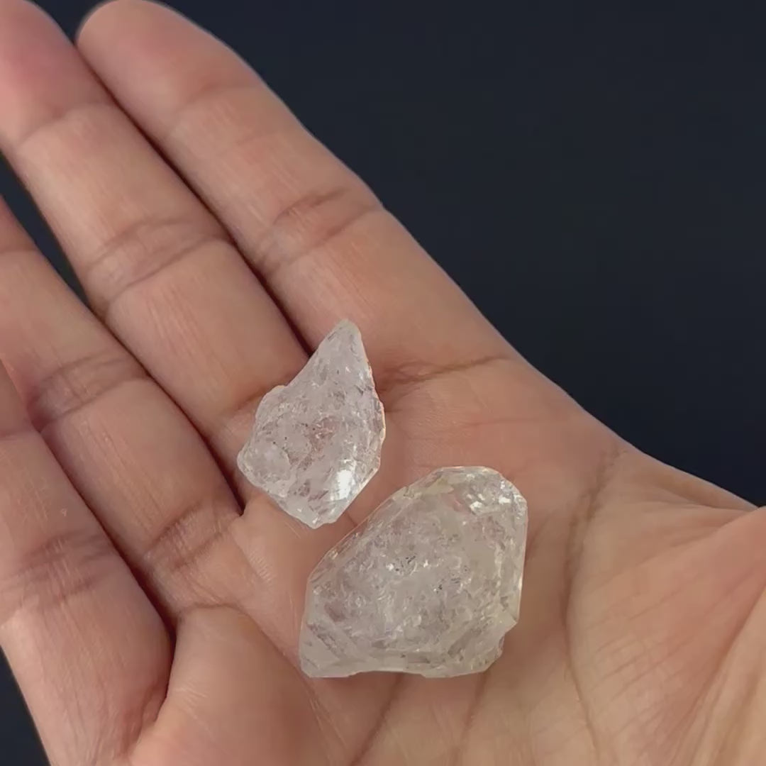 A video person holds delicate pieces of Herkimer Diamond rough, showcasing their terminated point design and sparkle.