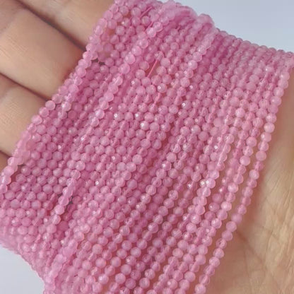A video person holds delicate strands of Pink Quartz beads, showcasing their faceted rondelle design and sparkle