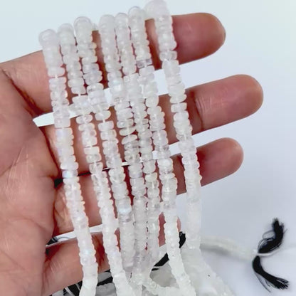 A video person holds delicate pieces of Moonstone smooth wheels, showcasing their design and shine.