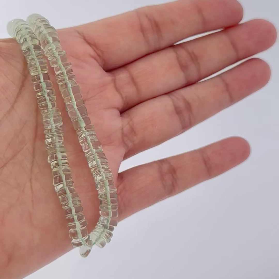 Smooth wheel-cut green amethyst beads, 6.5–7.0mm, arranged on a 21cm strand.