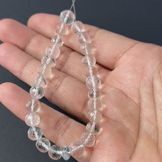 A video person holds delicate strands of rose quartz and aquamarine beads, showcasing their faceted round design and sparkle.
