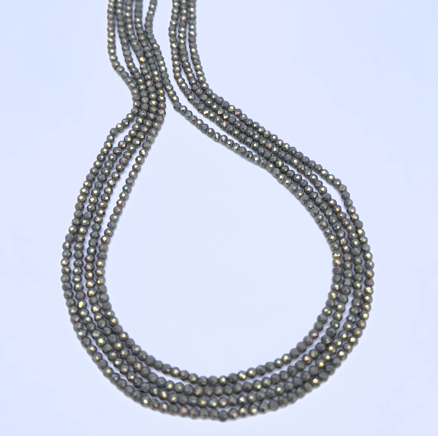 Close-up of Pyrite gemstone beads showing faceted cut and metallic grey surface.