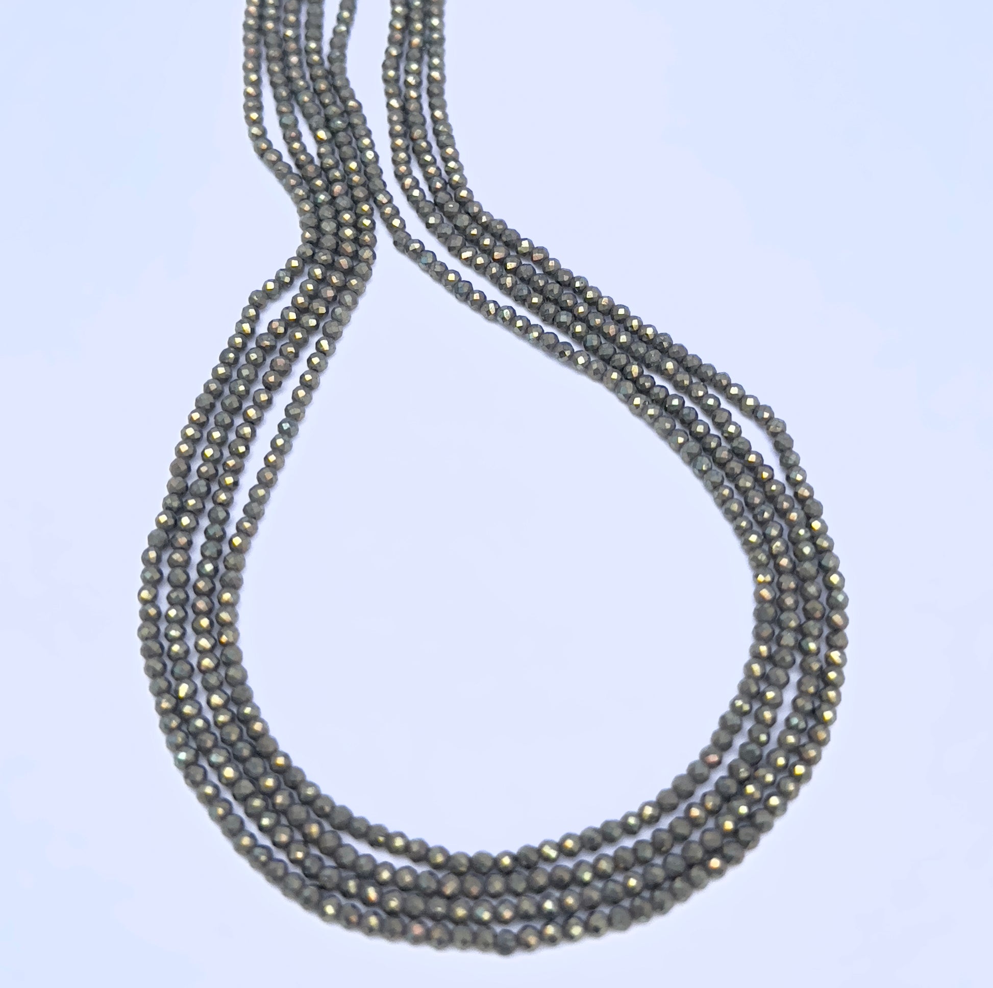 Close-up of Pyrite gemstone beads showing faceted cut and metallic grey surface.