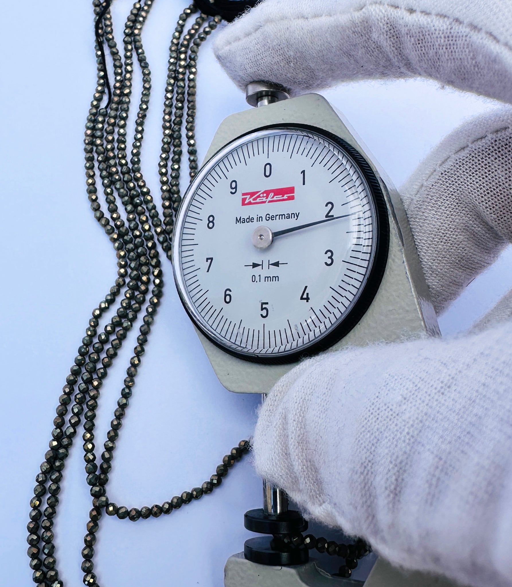 A dial gauge measures the Pyrite faceted rondelle 2.1mm gemstone.
