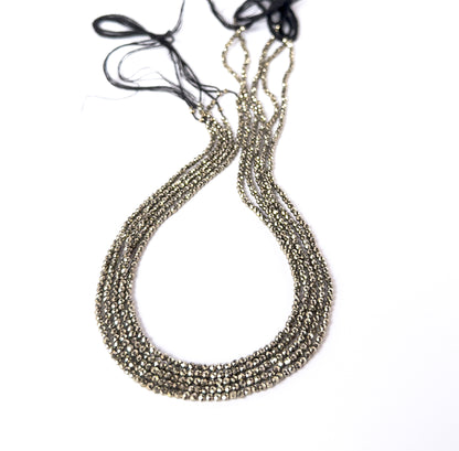 Pyrite faceted rondelle gemstone beads in metallic gold tones arranged on a strand for handmade jewellery components.