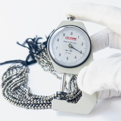 A dial gauge measures the Pyrite faceted rondelle 3.1mm gemstone.