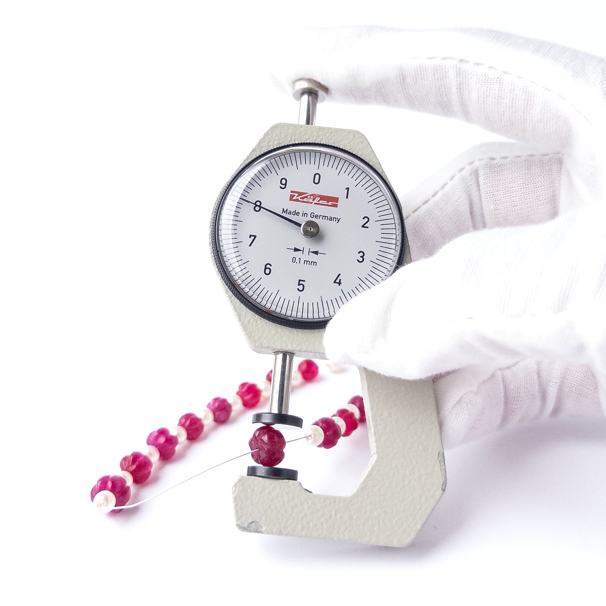 A dial gauge measures the Quartz and Shell Pearl pumpkin‑cut 6–8mm gemstone.
