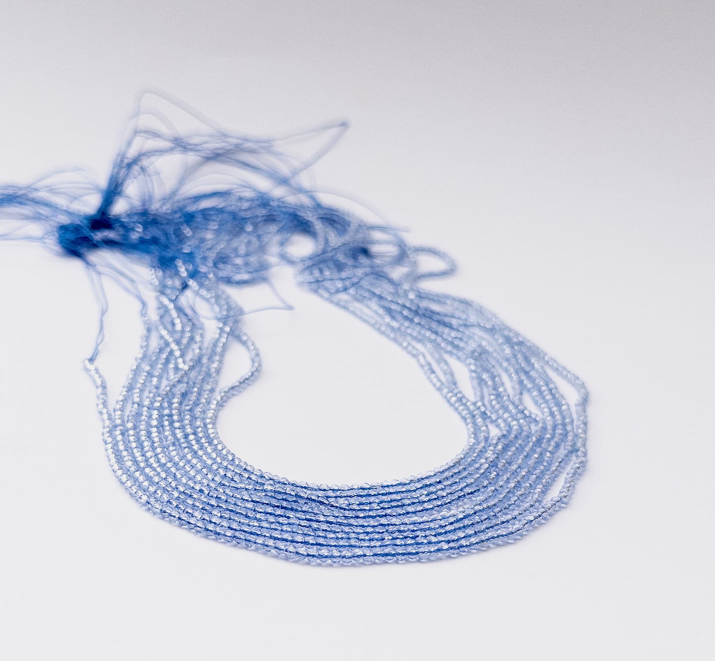 Quartz faceted rondelle beads arranged in a strand showing bright sparkle and fine micro‑cut detailing.