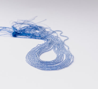 Close‑up of clear Quartz faceted rondelle beads with crisp light reflection and uniform micro size.