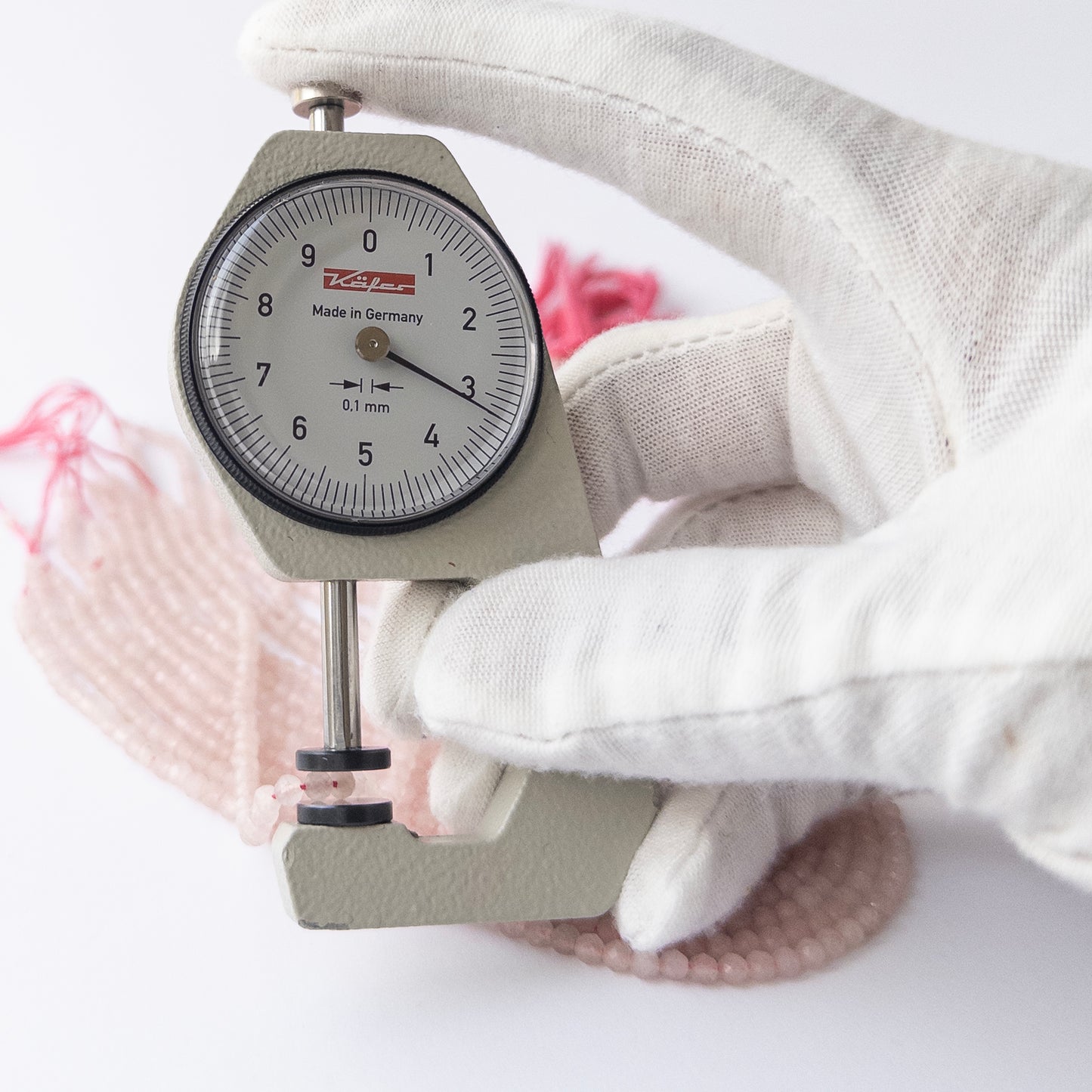 A dial gauge measures the Quartz faceted rondelle 3.2–3.4mm gemstone.