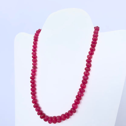 Quartz necklace with melon-cut beads in rich pink tones displayed on a bust stand.