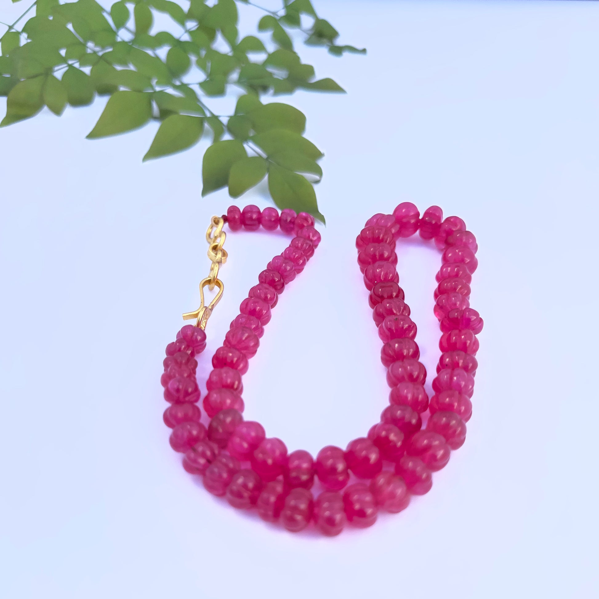 Close-up of Quartz gemstone beads showing sculpted melon-cut ridges and polished finish.