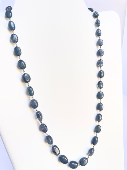 Close-up of Quartz gemstone beads, smooth oval cut, shimmering brilliance, arranged in a strand.