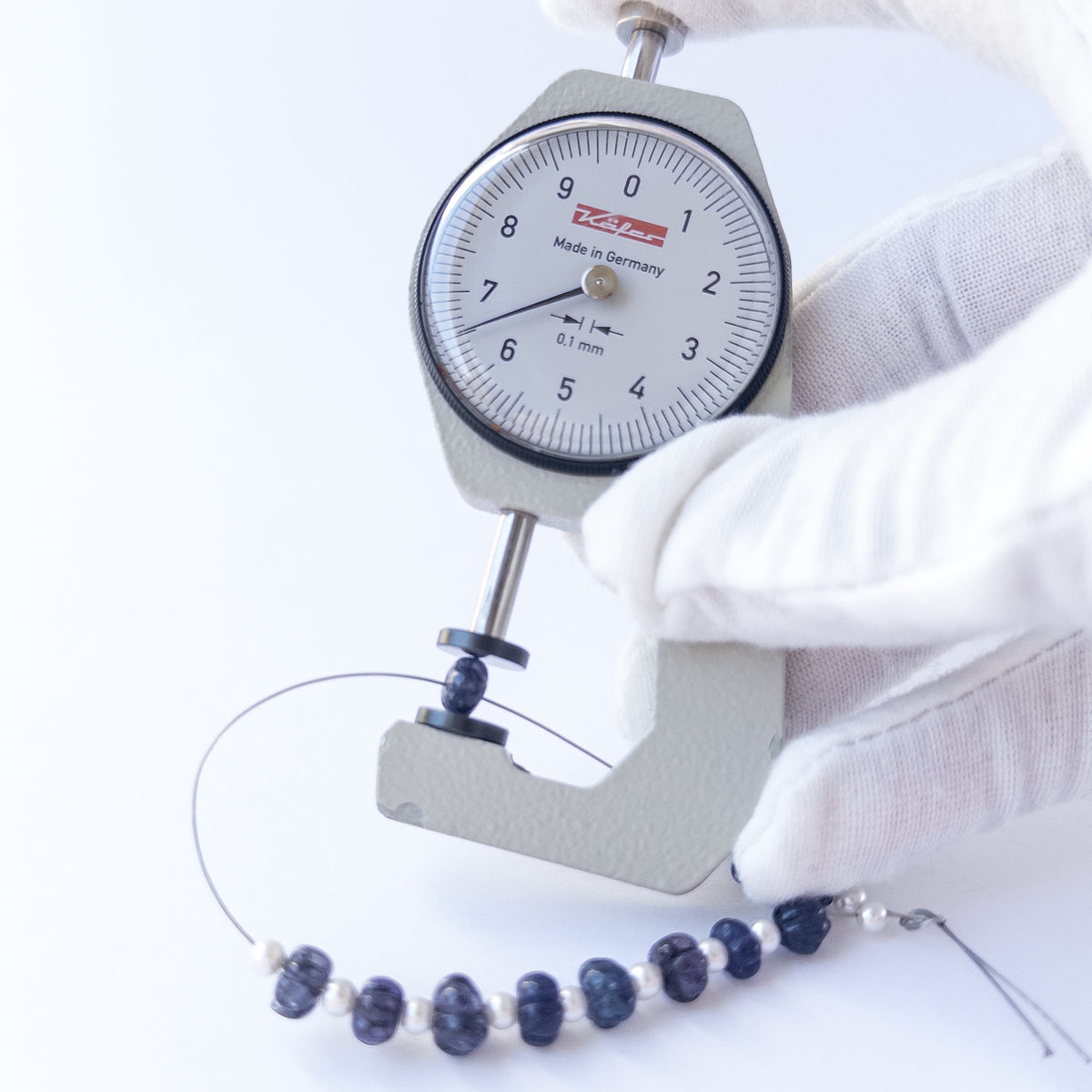 A dial gauge measures the Quartz pumpkin cut 6mm gemstone.