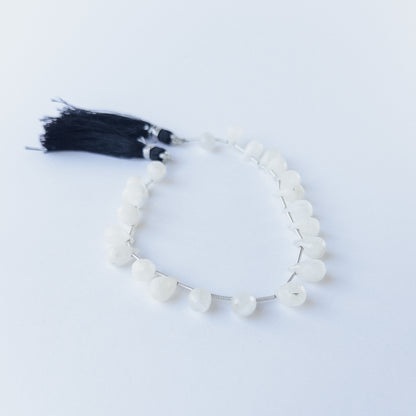 Authentic Rainbow Moonstone gemstone beads with faceted briolette cut arranged neatly in a small 17‑piece set.
