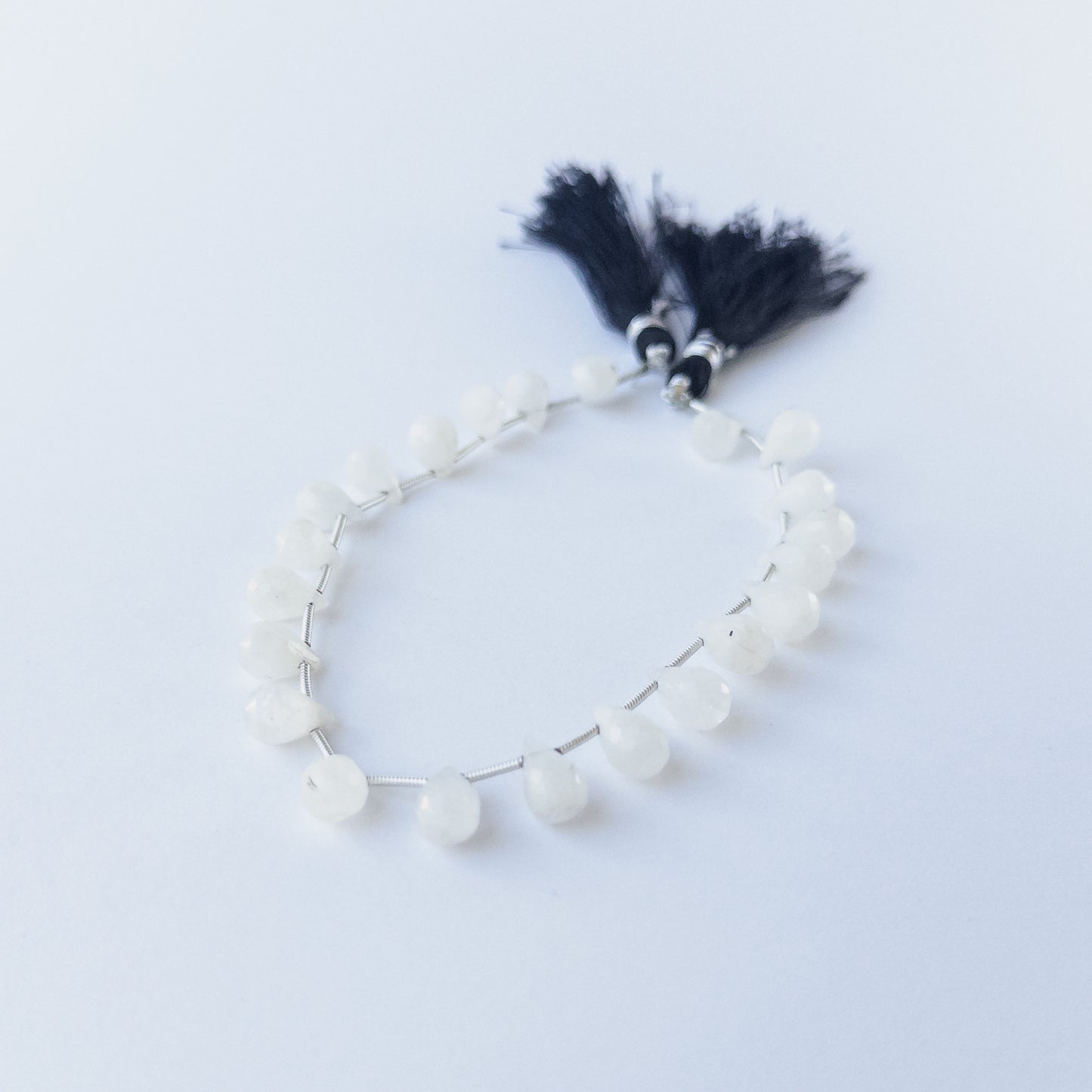 Close‑up of Rainbow Moonstone faceted briolette beads showing clarity, sparkle and high‑quality craftsmanship.