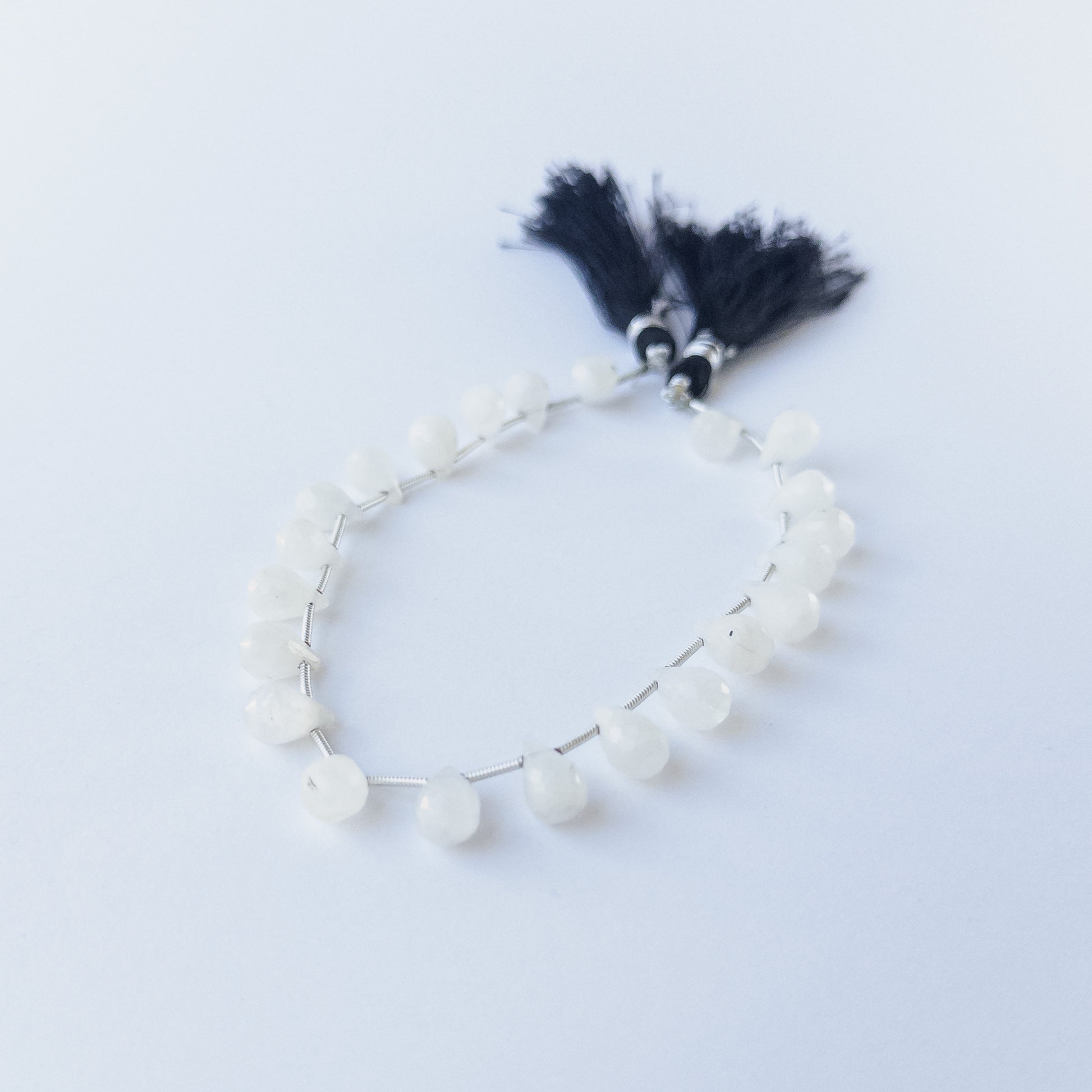 Close‑up of Rainbow Moonstone faceted briolette beads showing clarity, sparkle and high‑quality craftsmanship.