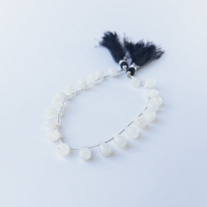 Close‑up of Rainbow Moonstone faceted briolette beads showing clarity, sparkle and high‑quality craftsmanship.