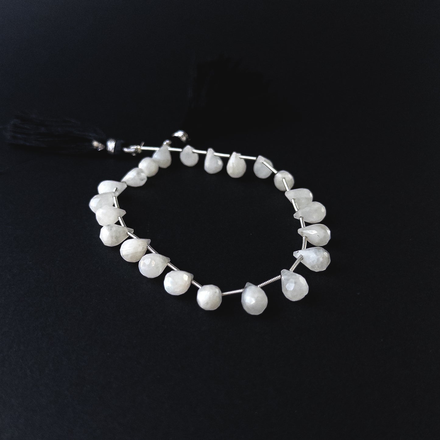 Handmade jewellery components featuring Rainbow Moonstone briolettes with polished facets and luminous sheen.