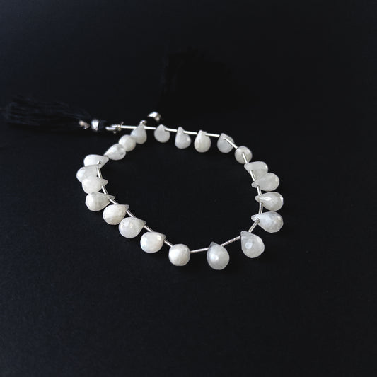 Handmade jewellery components featuring Rainbow Moonstone briolettes with polished facets and luminous sheen.