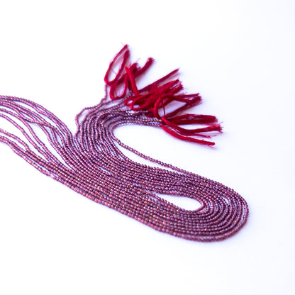 Handmade jewellery components featuring natural Rhodolite Garnet faceted rondelles, highlighting their colour, clarity, and shimmering finish.