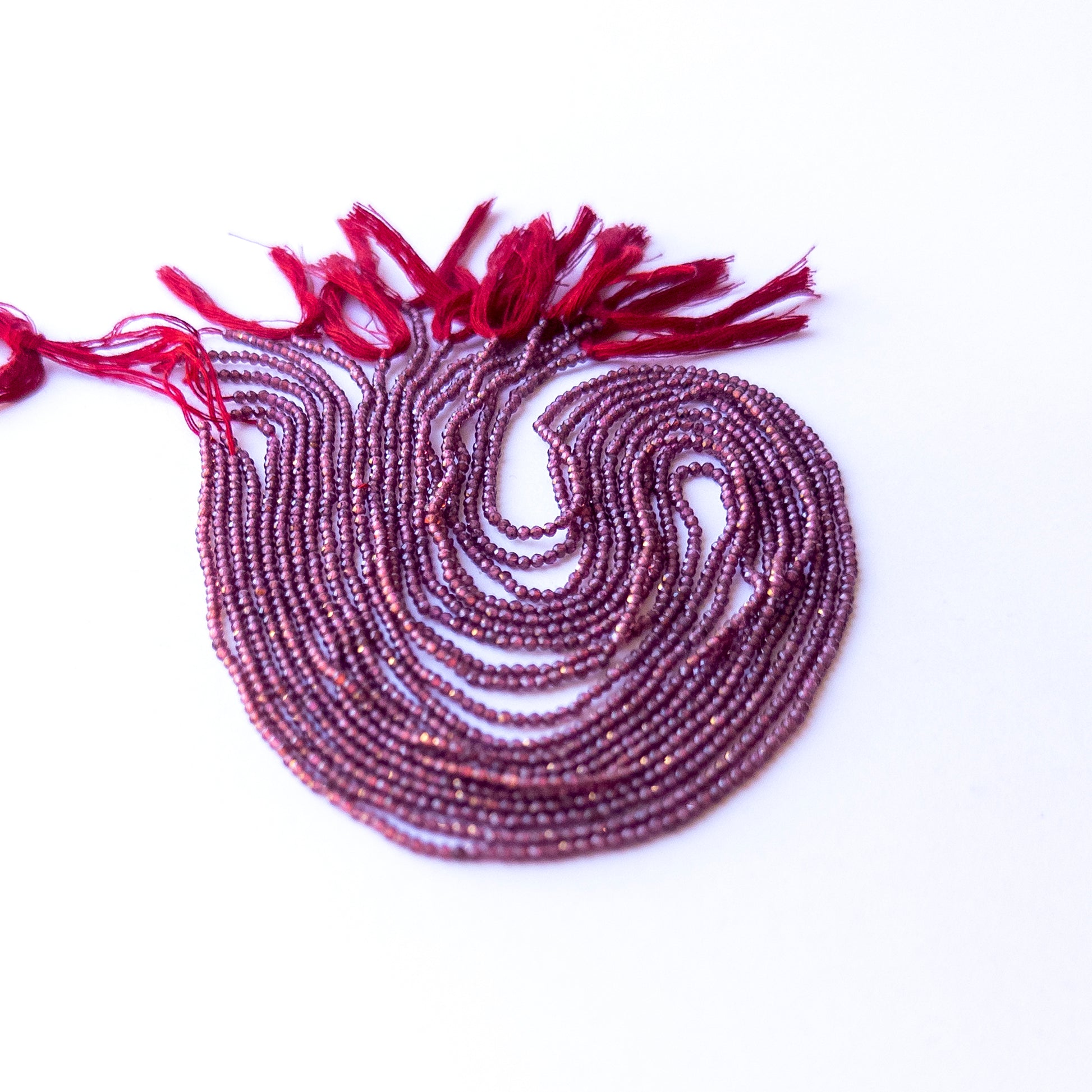 Close‑up of authentic Rhodolite Garnet faceted rondelle beads showing their sparkle and consistent 1.9mm sizing.