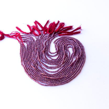 Close‑up of authentic Rhodolite Garnet faceted rondelle beads showing their sparkle and consistent 1.9mm sizing.