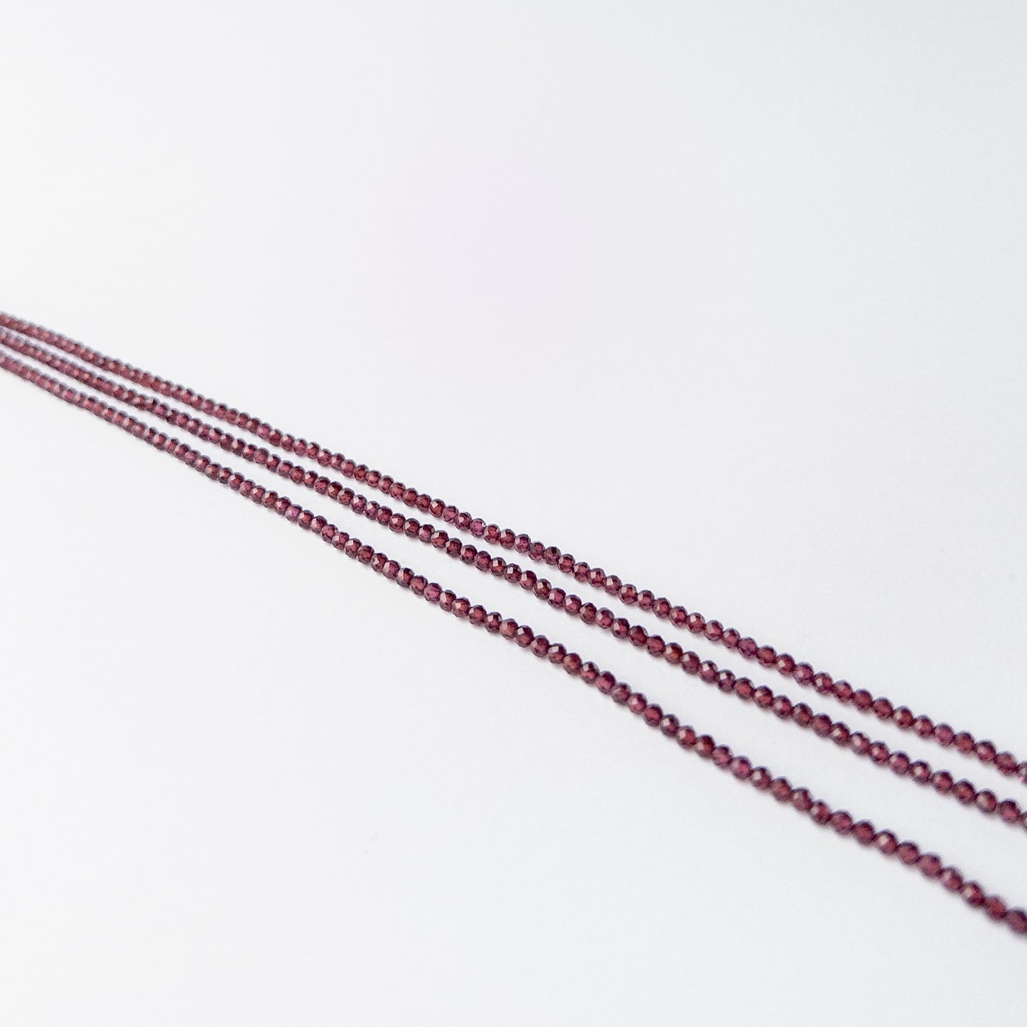 Berry red Rhodolite Garnet gemstone beads arranged neatly for DIY jewellery and beadwork projects.