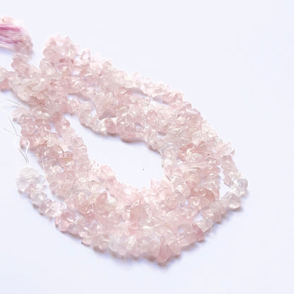 Handmade jewellery components featuring rose quartz chips with varied shapes and polished surfaces.