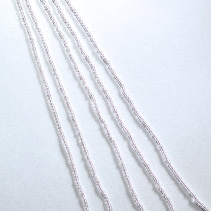 Rose Quartz gemstone beads in faceted rondelle cut reflect soft light across the strand.