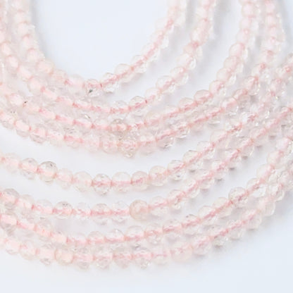 Faceted rondelle Rose Quartz beads arranged neatly, highlighting their polished finish and handmade jewellery component quality