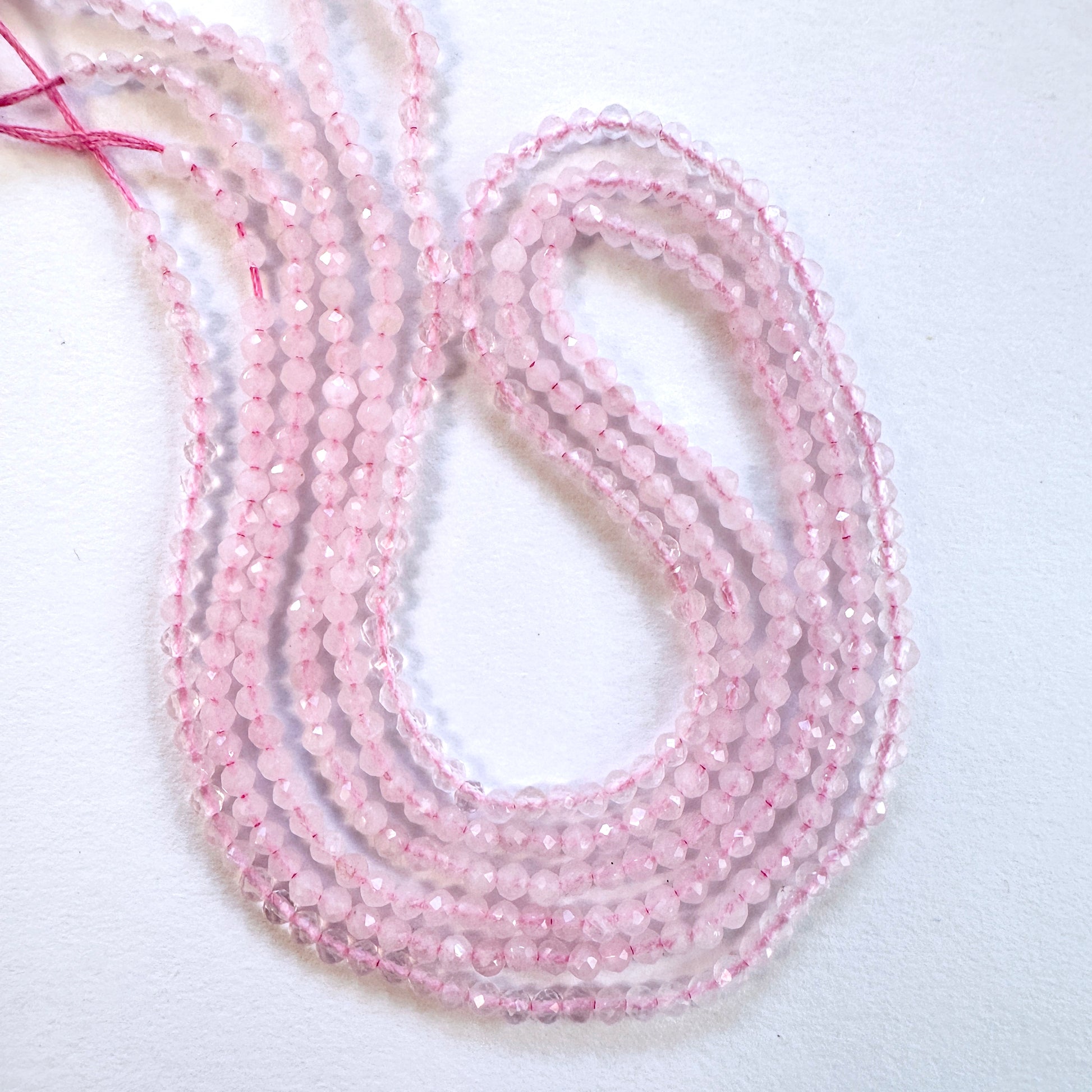 Close-up of Rose Quartz faceted rondelle beads with soft pink tones and sparkling finish.