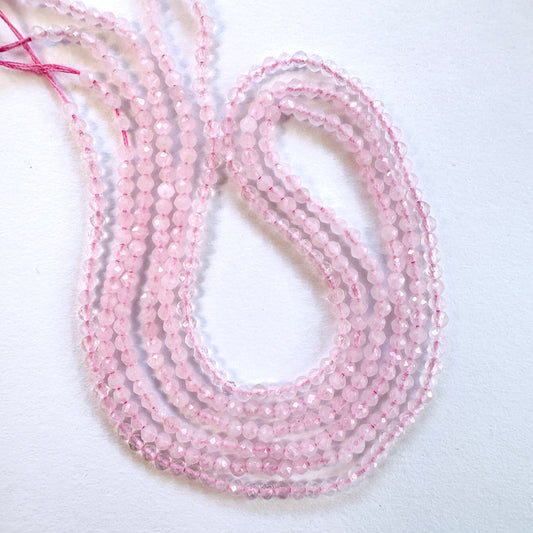 Close-up of Rose Quartz faceted rondelle beads with soft pink tones and sparkling finish.