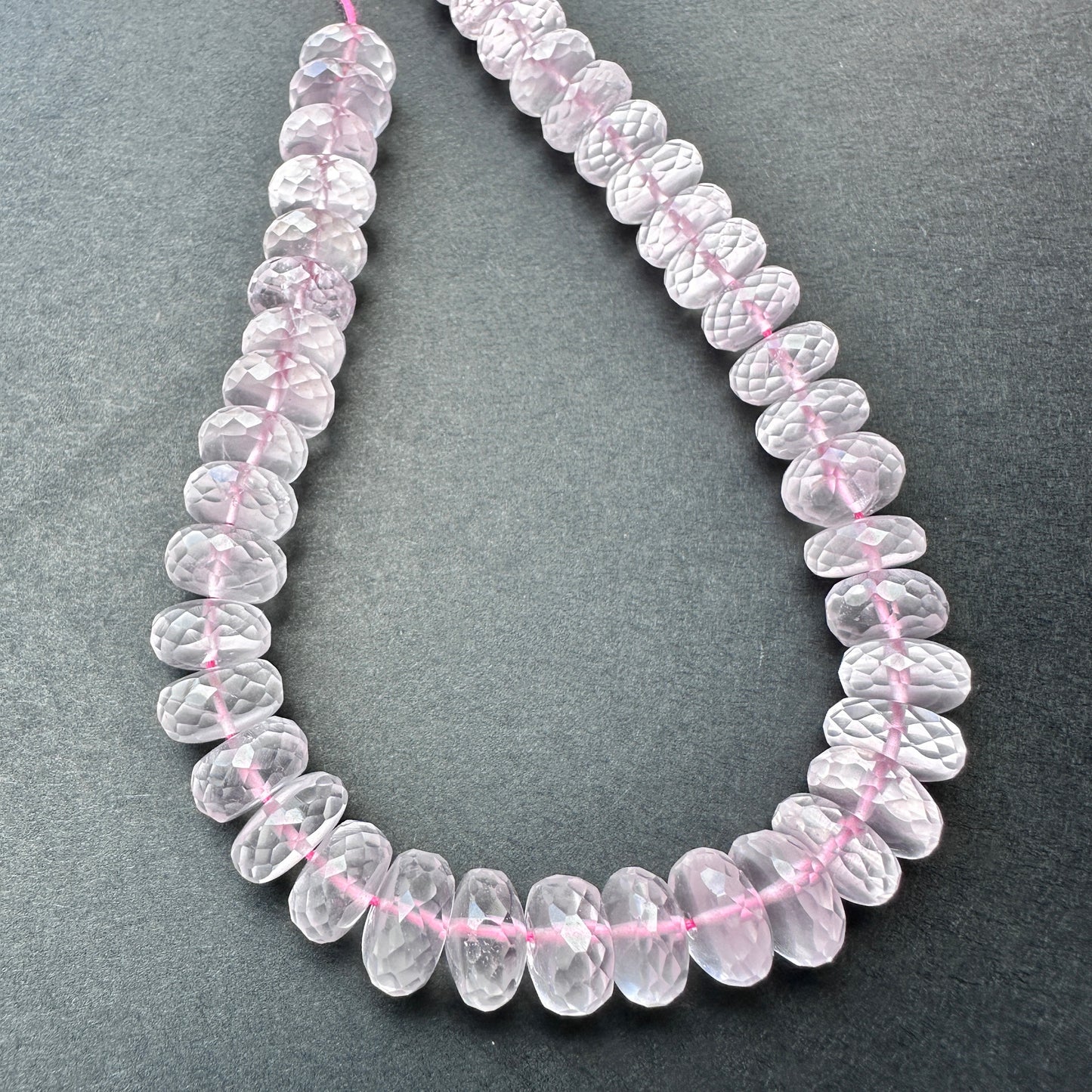 Rose Quartz micro faceted rondelle beads with soft blush tones arranged on a 22cm strand for jewellery making.