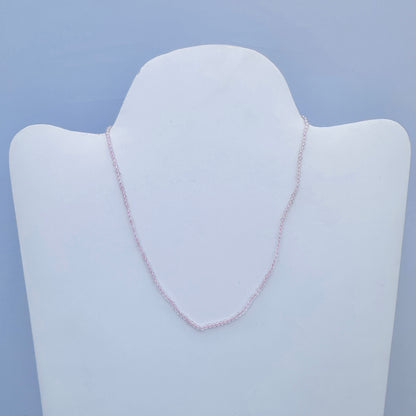 Close-up of Rose Quartz gemstone necklace showing delicate sparkle and polished finish.
