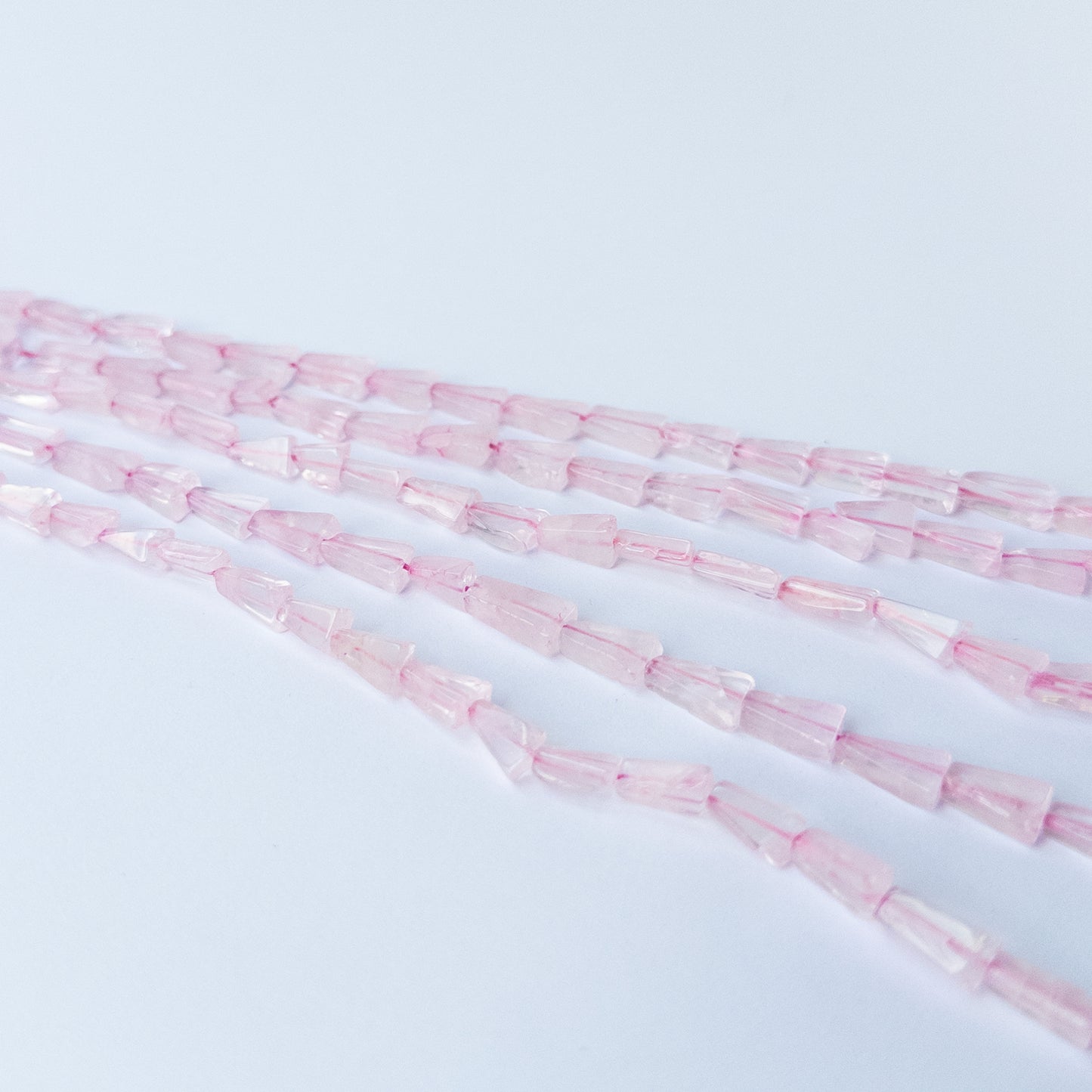 Rose Quartz tapered rectangle gemstone beads arranged on a 32cm strand for handmade jewellery components.