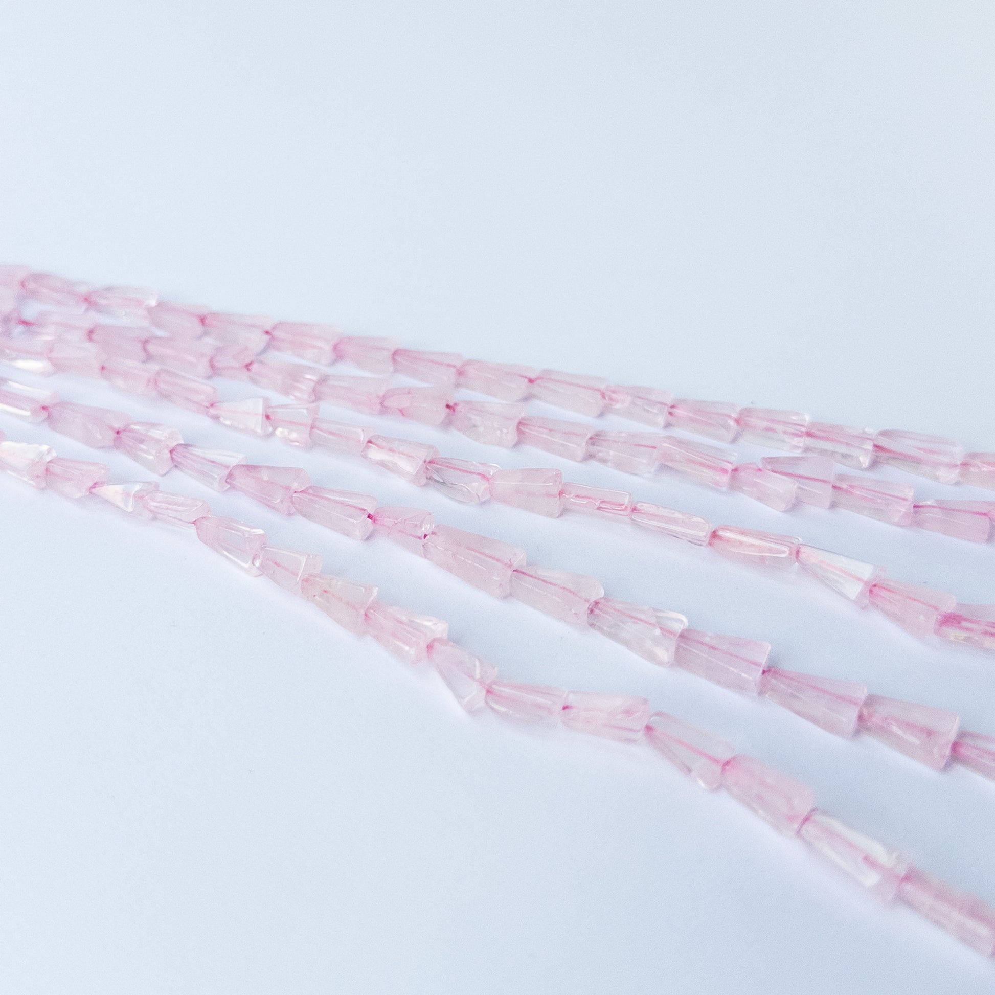 Rose Quartz tapered rectangle gemstone beads arranged on a 32cm strand for handmade jewellery components.