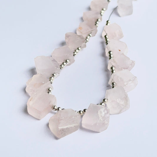 Close‑up of rose quartz rough beads highlighting their organic shape and gentle pastel colour for DIY jewellery.