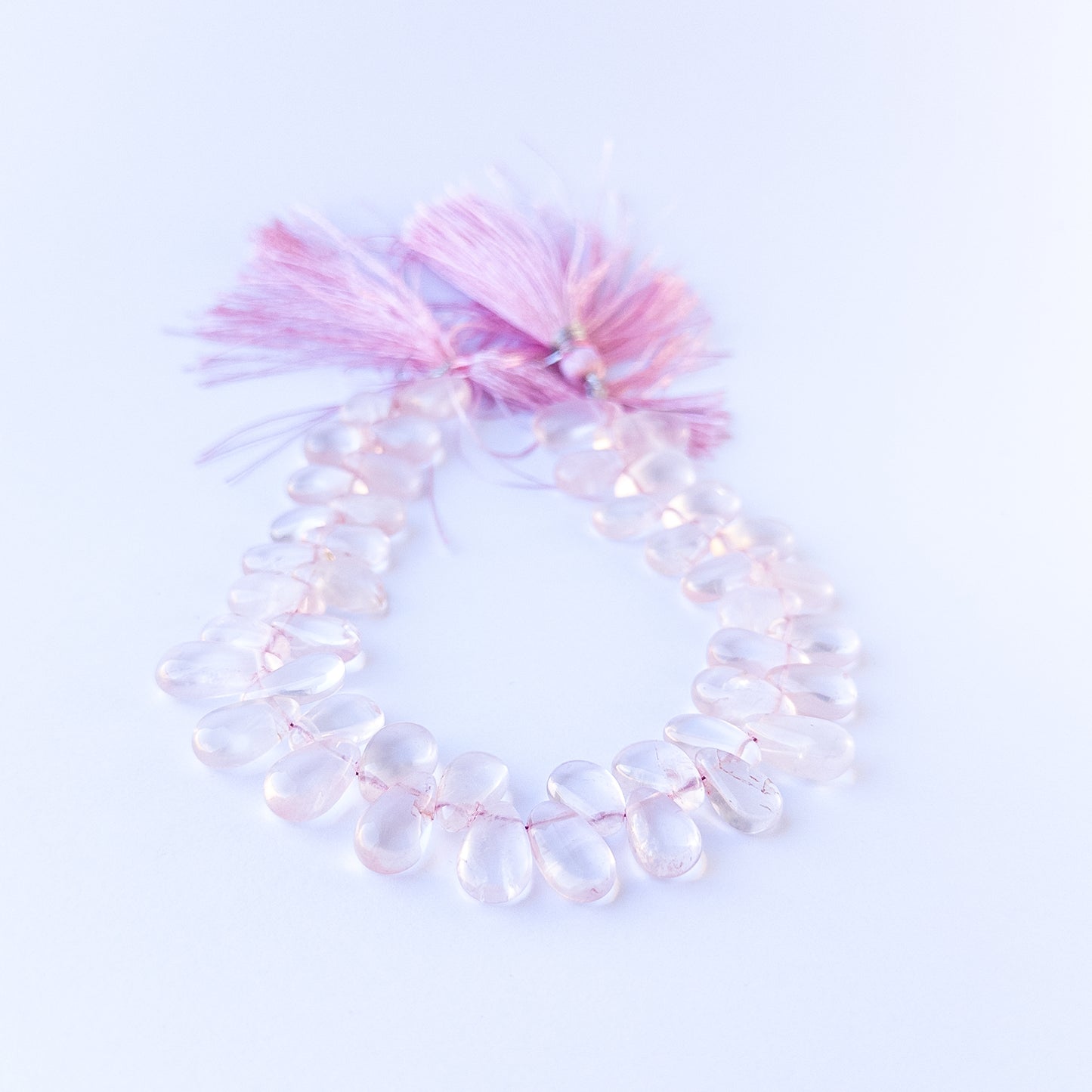 High‑quality rose quartz briolette gemstone beads with gentle shine and natural colour variation on a long strand.