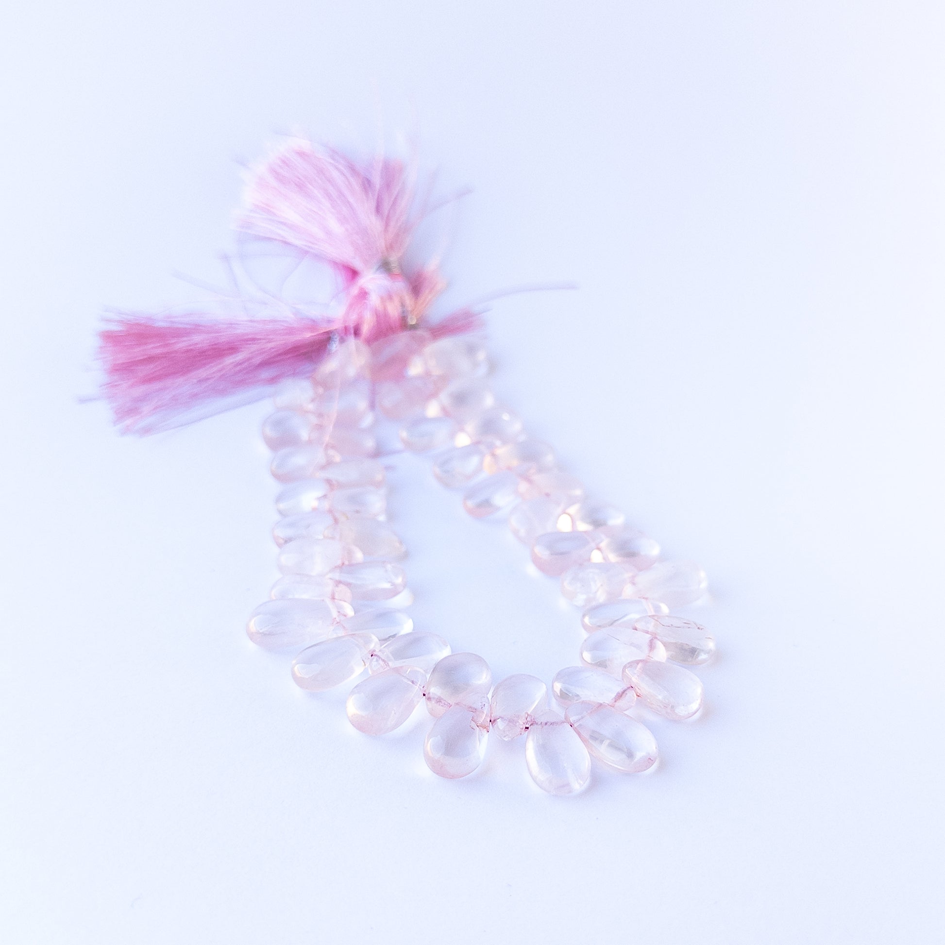 Handmade jewellery components featuring natural rose quartz smooth briolettes with soft tones and polished glow.